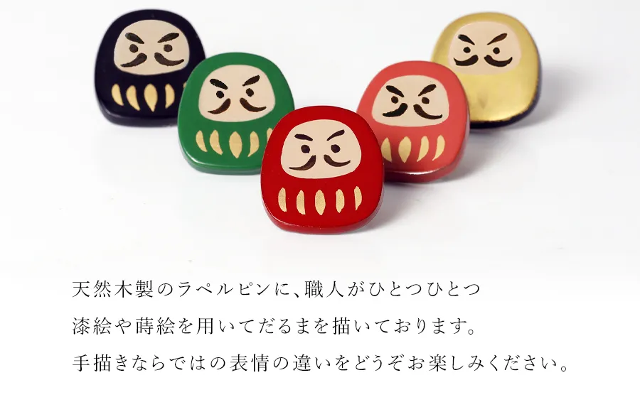 天然木製のラペルピンに、職人がひとつひとつ漆絵や蒔絵を用いてだるまを描いております。手描きならではの表情の違いをどうぞお楽しみください。